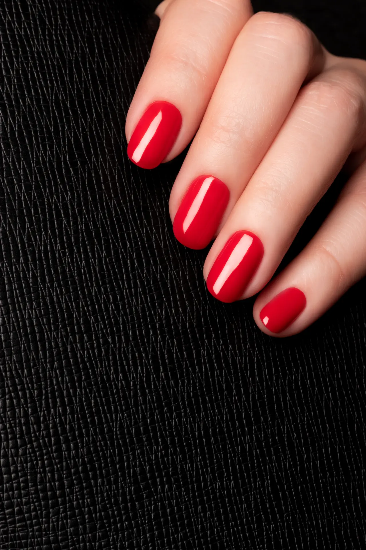 Hand with glossy red bio gel nails.