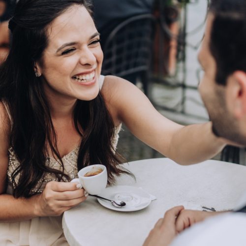 Happy woman caressing husband face on a coffee date