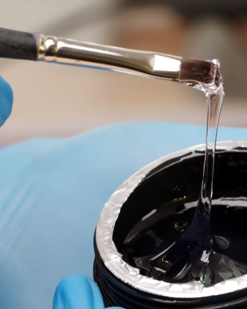 Dipping brush into black epoxy resin.