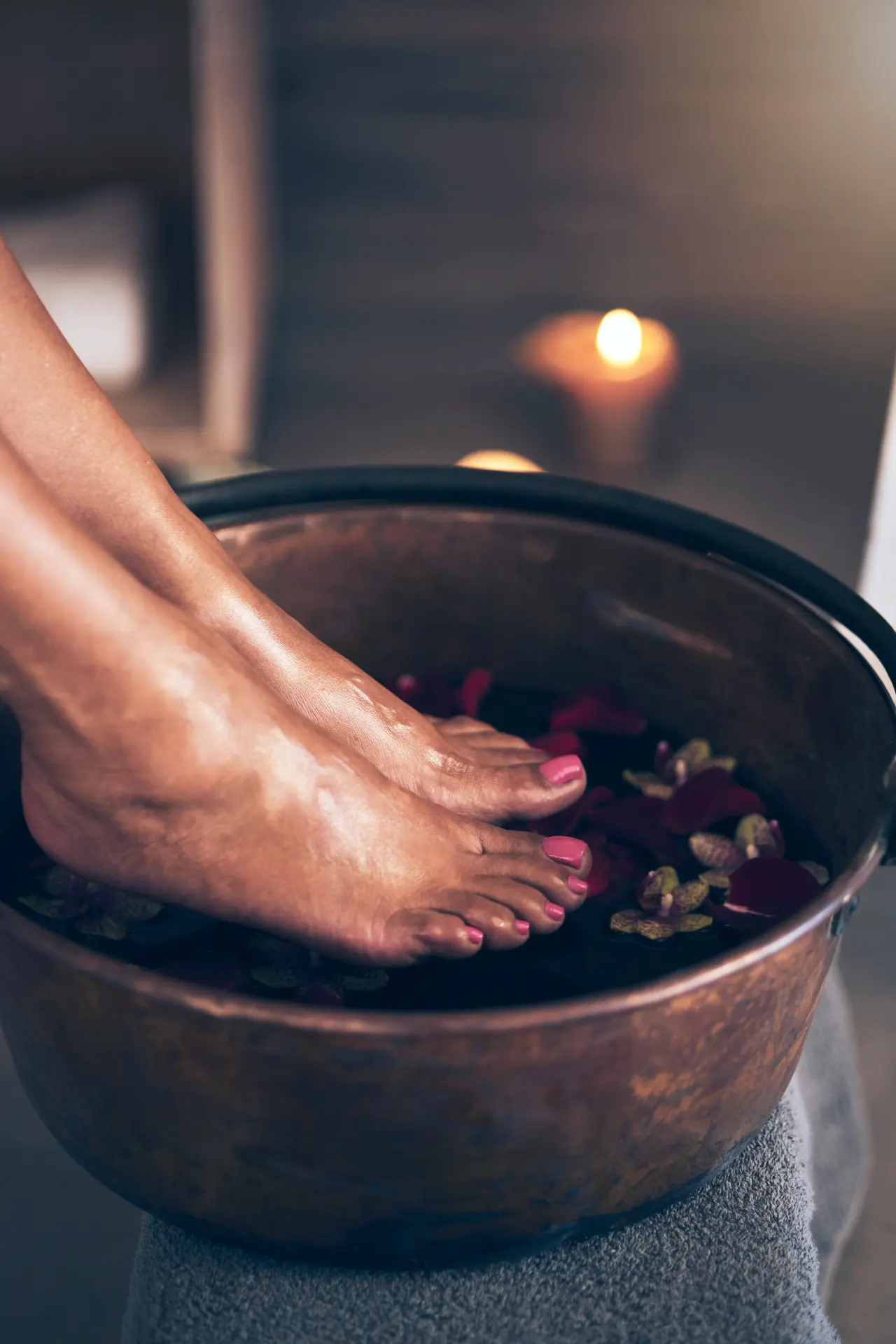 Feet soaking in a luxurious flower pedicure bath.